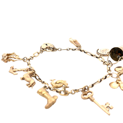 9ct yellow gold charm bracelet by Reeves and Sons, 16.3g, featuring multiple dangling charms
