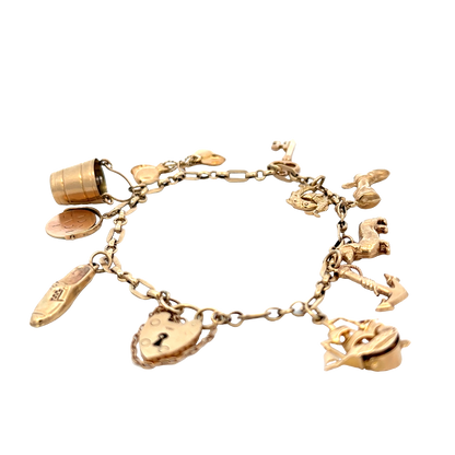 9ct yellow gold charm bracelet by Reeves and Sons, 16.3g, featuring multiple dangling charms