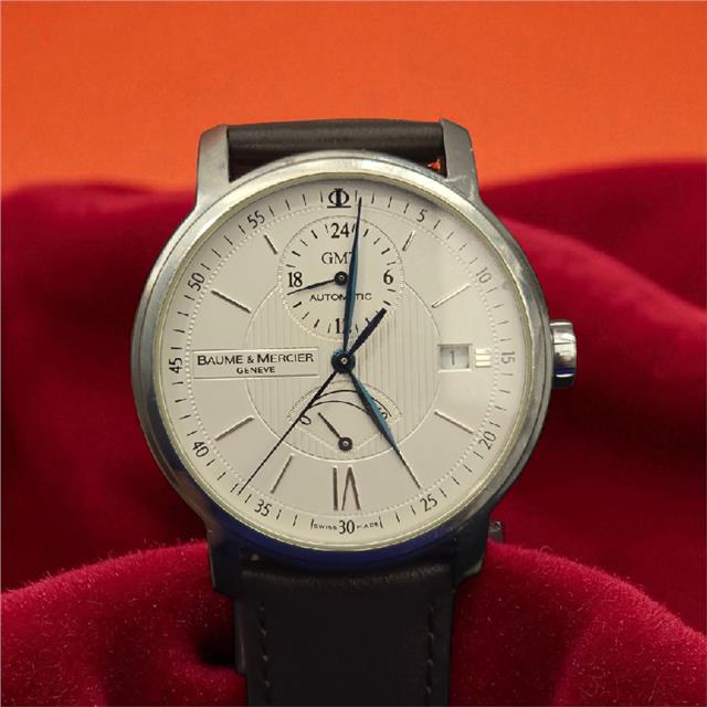 Baume & Mercier GMT automatic dual time power reserve watch with black dial and stainless steel case.
