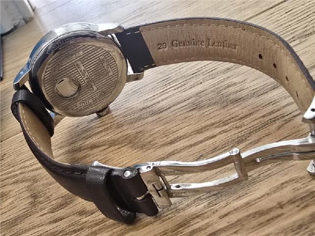 Baume & Mercier GMT automatic dual time watch showing power reserve and dual time display on a sleek dial.