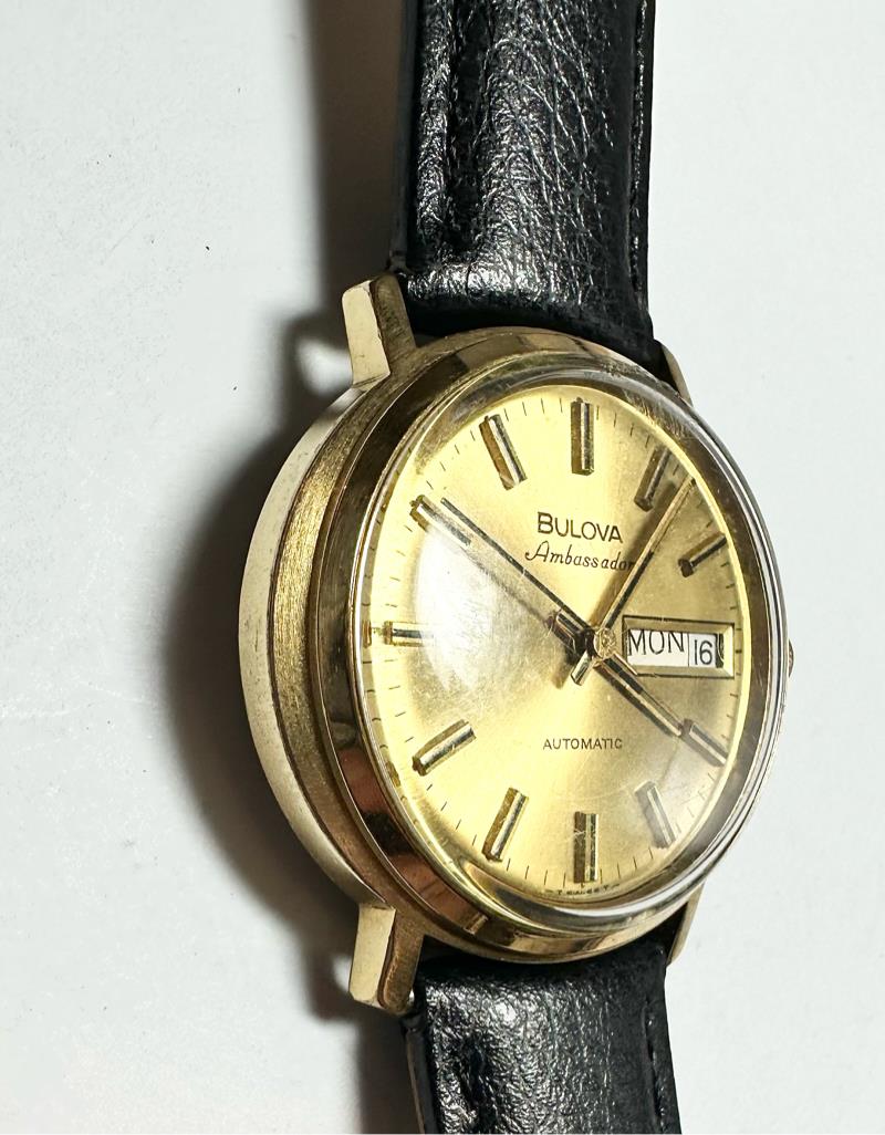 Bulova plated automatic watch with sleek design, weighing 44.9g, featuring a polished finish and intricate dial details.