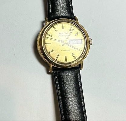 Bulova plated automatic watch with a sleek design, weighing 44.9g, featuring a polished metal finish and classic time display.