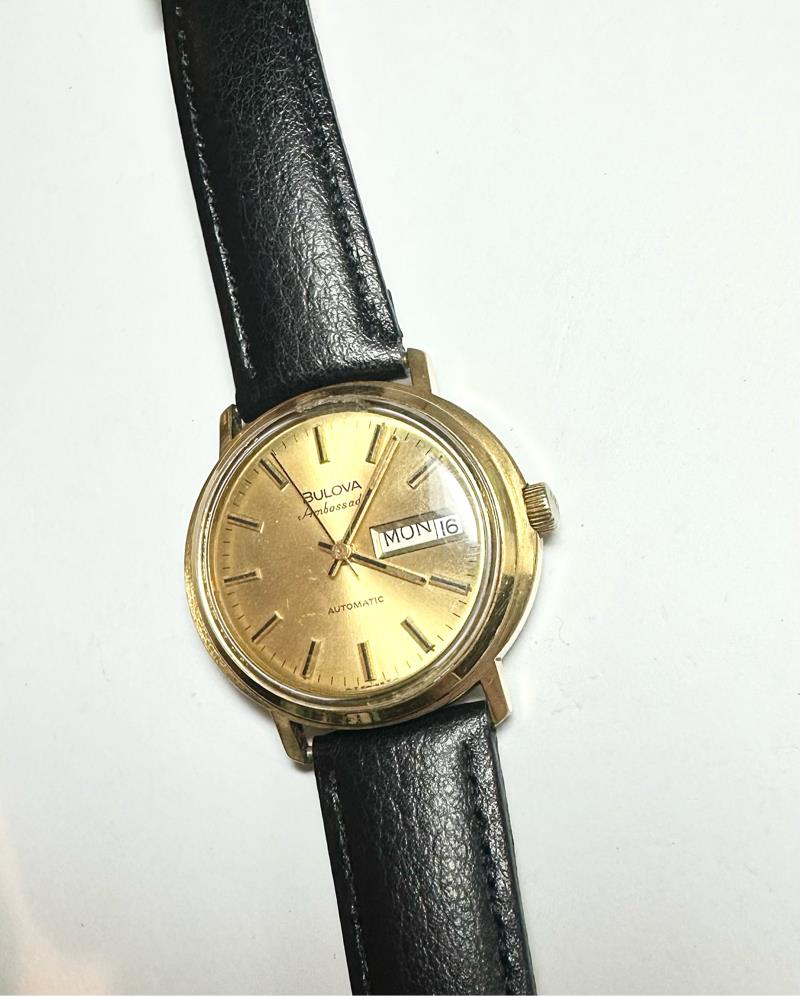 Bulova plated automatic wristwatch with stainless steel case, 44.9g, featuring a sleek design and classic watch face.