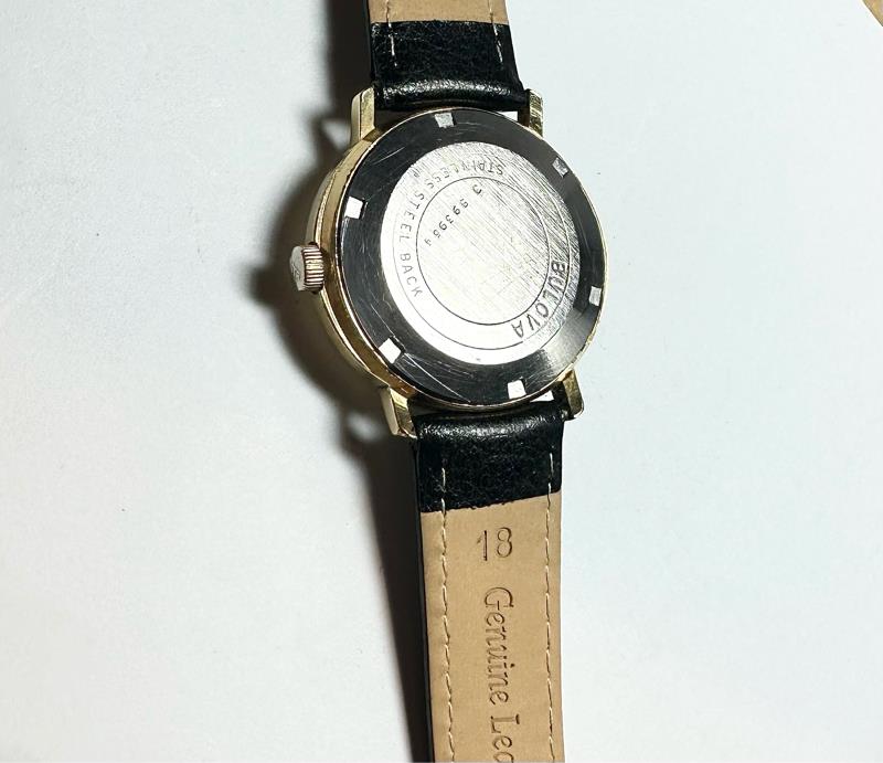 Bulova plated automatic watch with a sleek design, weighing 44.9 grams, featuring a stainless steel band and classic dial.