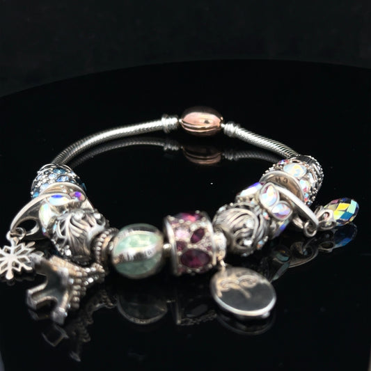 925 silver Chamilia charm bracelet featuring decorative charms and intricate details on a sleek silver chain.