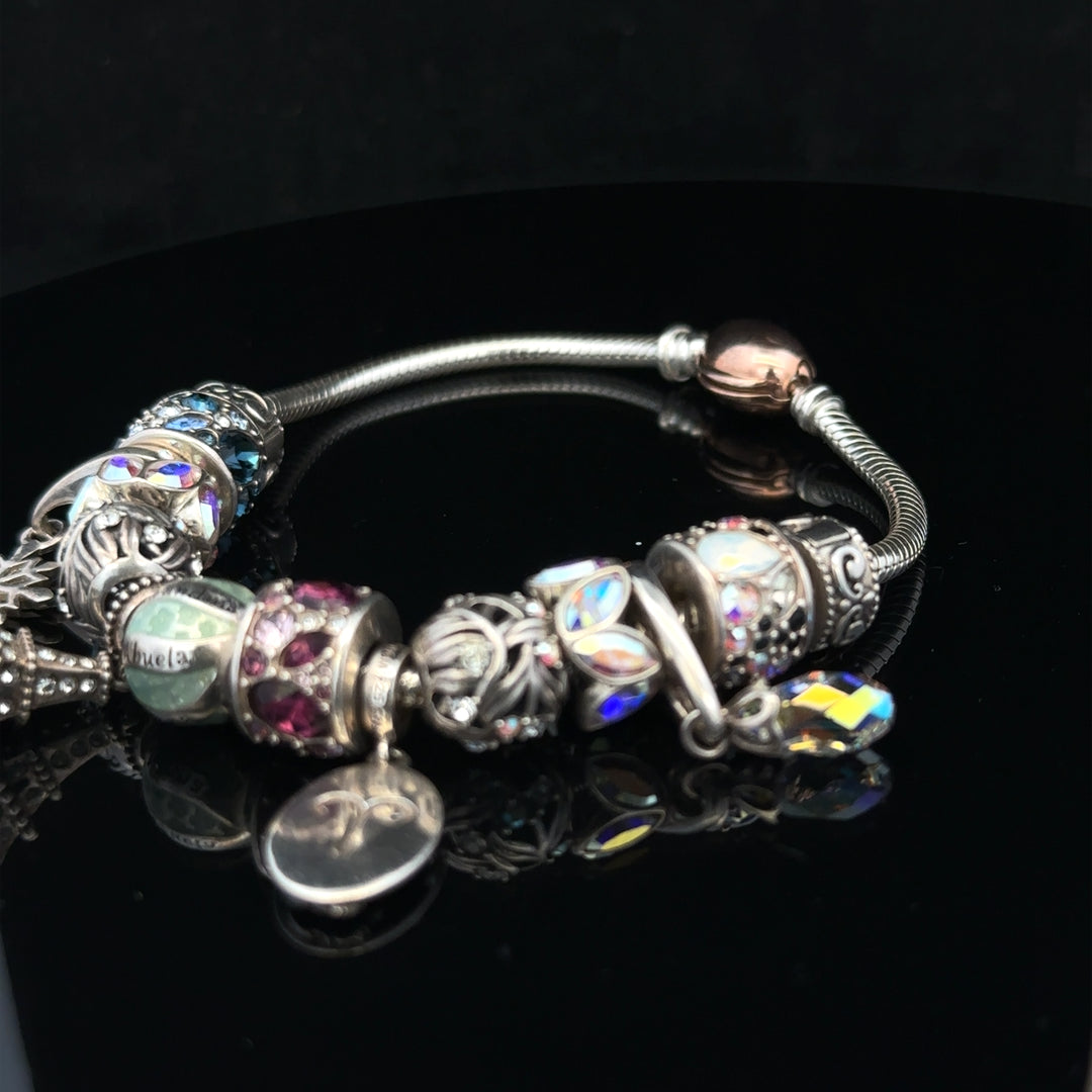 925 silver Chamilia charm bracelet with various decorative charms and clasp, showcasing elegant jewelry design.