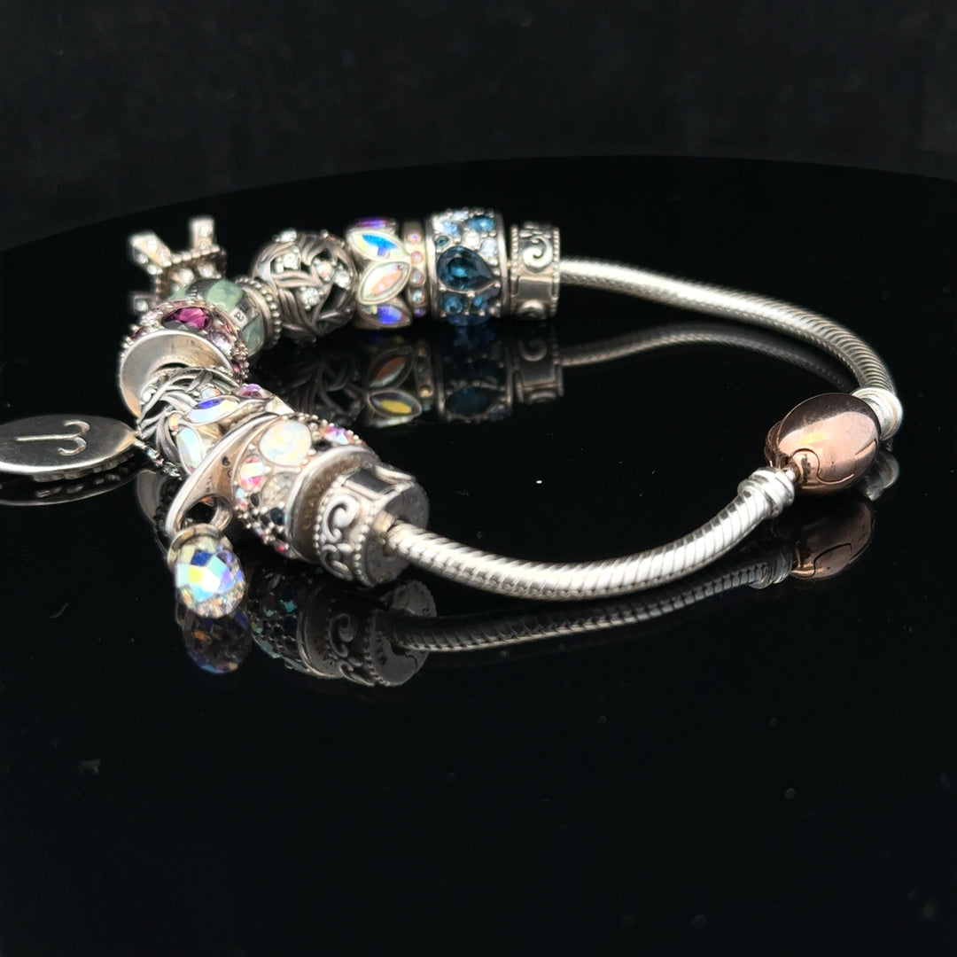 925 silver Chamilia charm bracelet with multiple charms and intricate details, showcasing elegant jewelry craftsmanship.