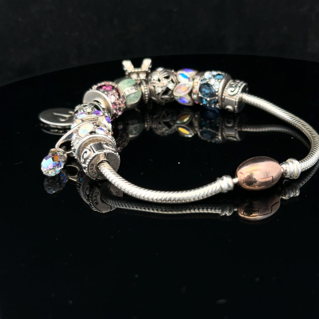925 silver Chamilia charm bracelet with various decorative charms on a delicate chain.