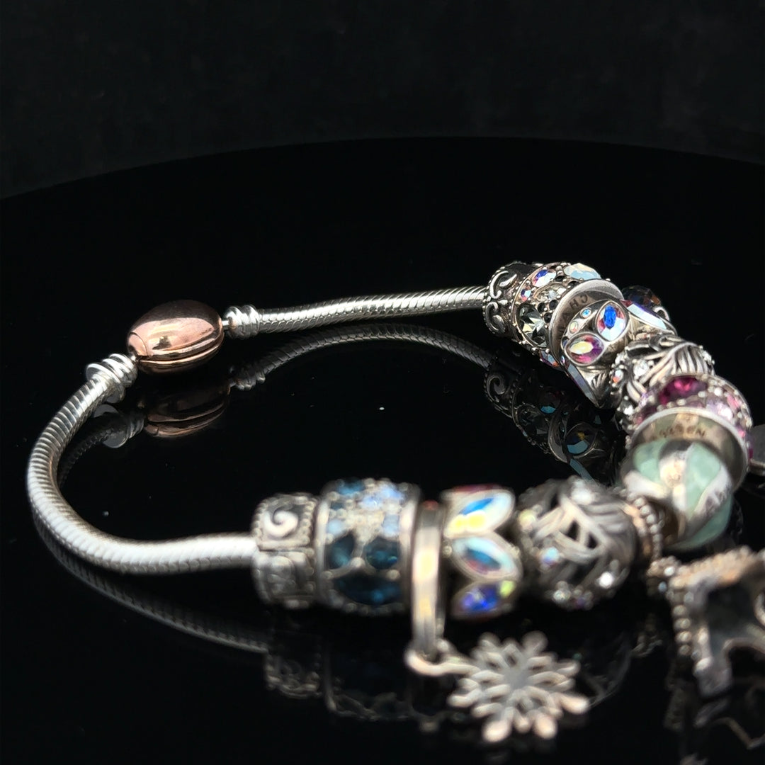 925 silver Chamilia charm bracelet featuring multiple elegant charms on a delicate chain.