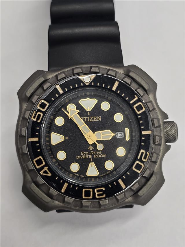 Citizen Eco-Drive titanium divers watch with black dial and stainless steel bracelet, designed for underwater use and durability.