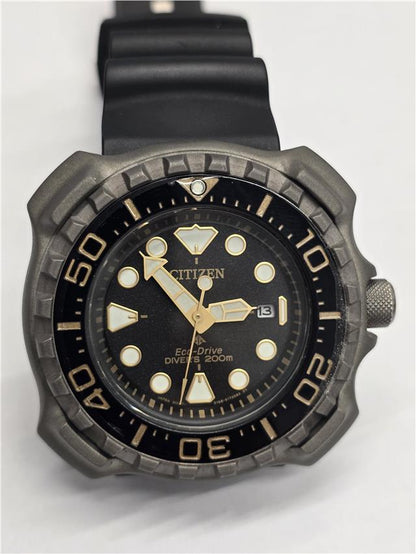 Citizen Eco-Drive titanium divers watch with black dial, stainless steel band, and unidirectional bezel.