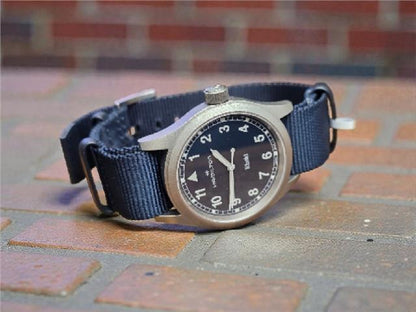 Hamilton Khaki Watch Age 2025 with black dial, stainless steel case, and strap, featuring a classic military-inspired design.