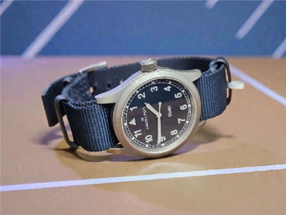 Hamilton Khaki Watch Age 2025 with black dial, stainless steel case, and leather strap, showcasing a classic military-inspired design.
