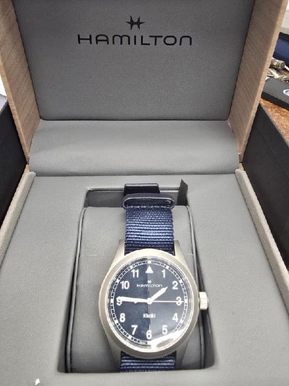 Hamilton Khaki Watch Age 2025 with black dial, stainless steel case, and leather strap, showcasing a sleek, modern design.