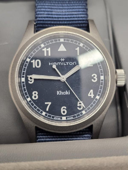 Hamilton Khaki Watch Age 2025 with black dial, stainless steel case, and leather strap, displayed on a neutral background.