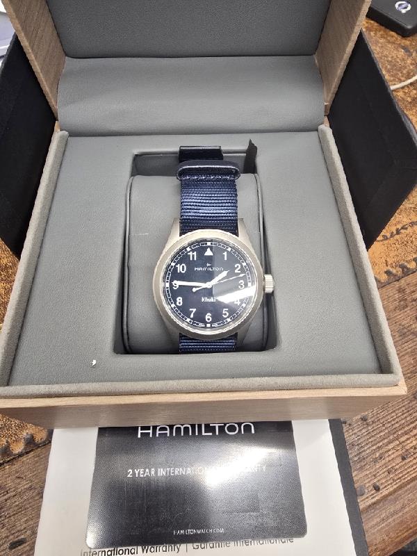 Hamilton Khaki Watch Age 2025 with black dial, stainless steel case, and adjustable strap, designed for a classic, military-inspired look.