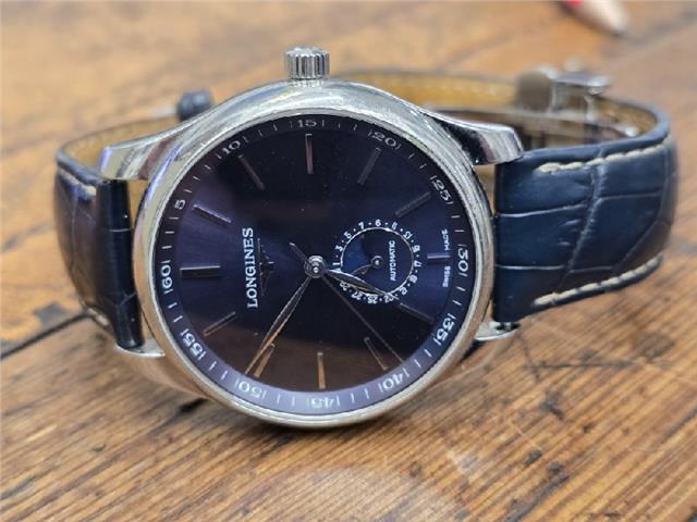 Longines Master Collection watch with boxed papers, featuring a stainless steel case and classic dial, photographed against a neutral background.
