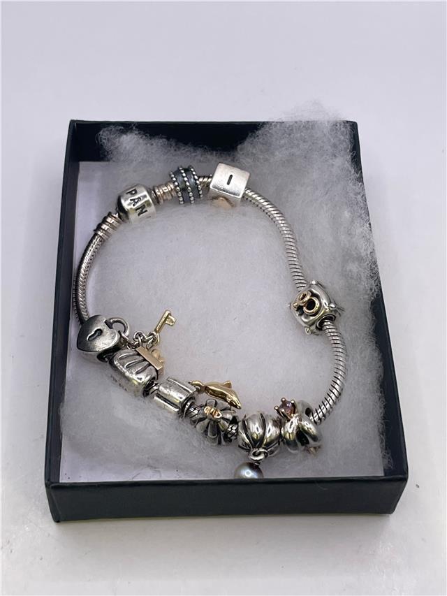 Silver Pandora bracelet with intricate design, weighing 42.3 grams, displayed on a neutral background.