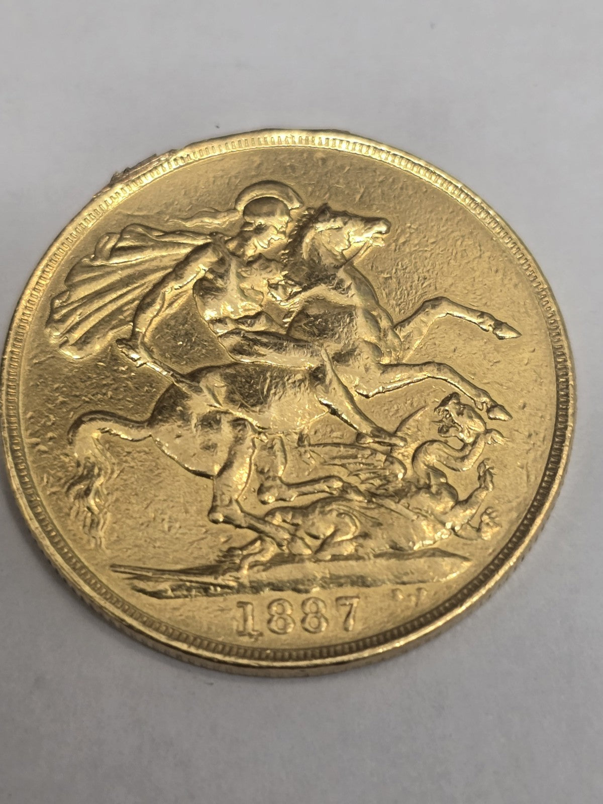 1887 Double Sovereign coin from Reeves and Sons, showing intricate gold design and historical details.