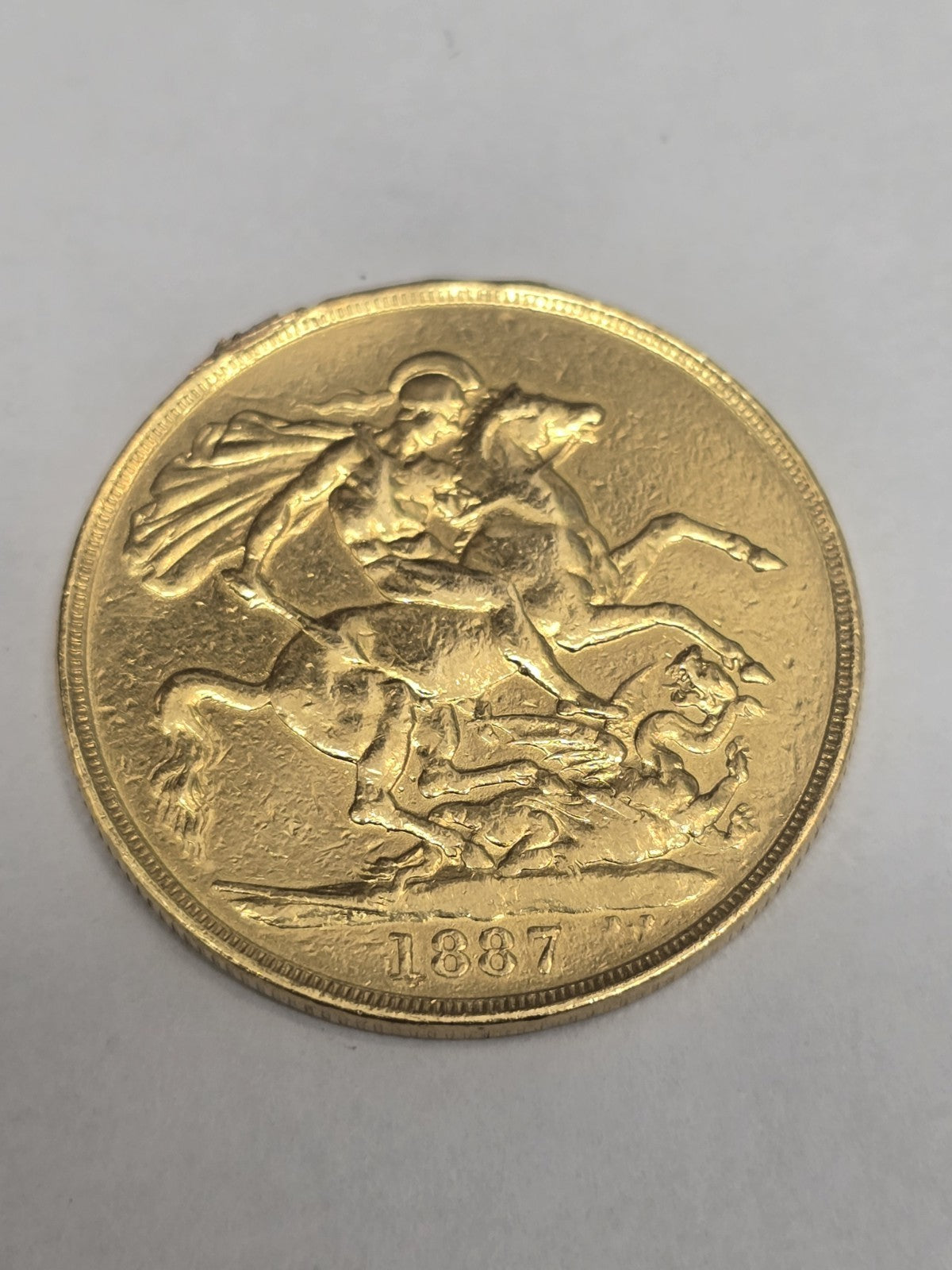 1887 Double Sovereign coin from Reeves and Sons, featuring detailed engravings and historical design on a gold-colored coin.
