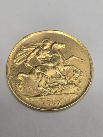 1887 Double Sovereign coin from Reeves and Sons, featuring detailed engravings and historical design on a gold-colored coin.