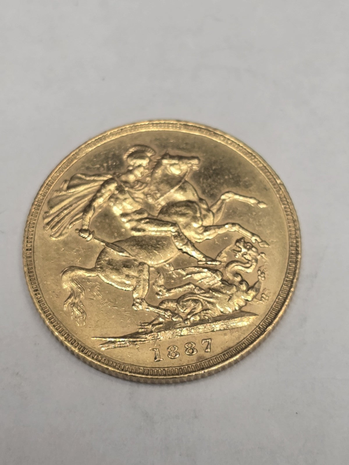 1887 Reeves and Sons full sovereign coin, 8g gold coin with detailed historic design and denomination visible.