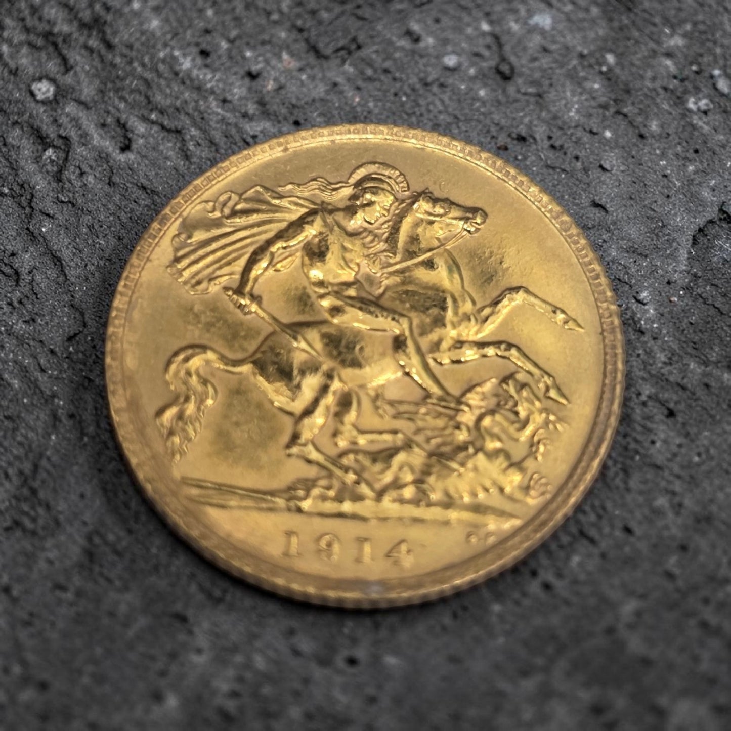 1914 Reeves and Sons Half Sovereign coin, 4g, showing detailed side with historical engravings and branding.