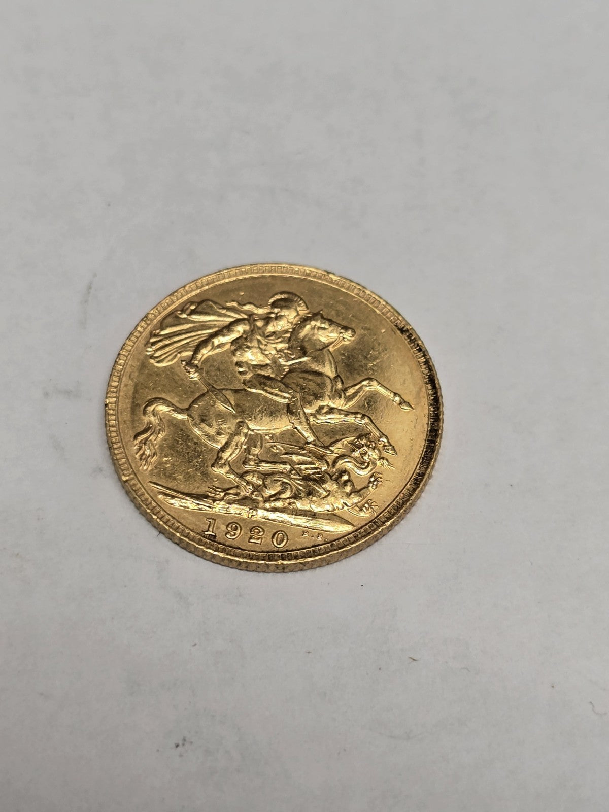 1920 full sovereign coin by Reeves and Sons, 8g gold coin with detailed design and historical features.