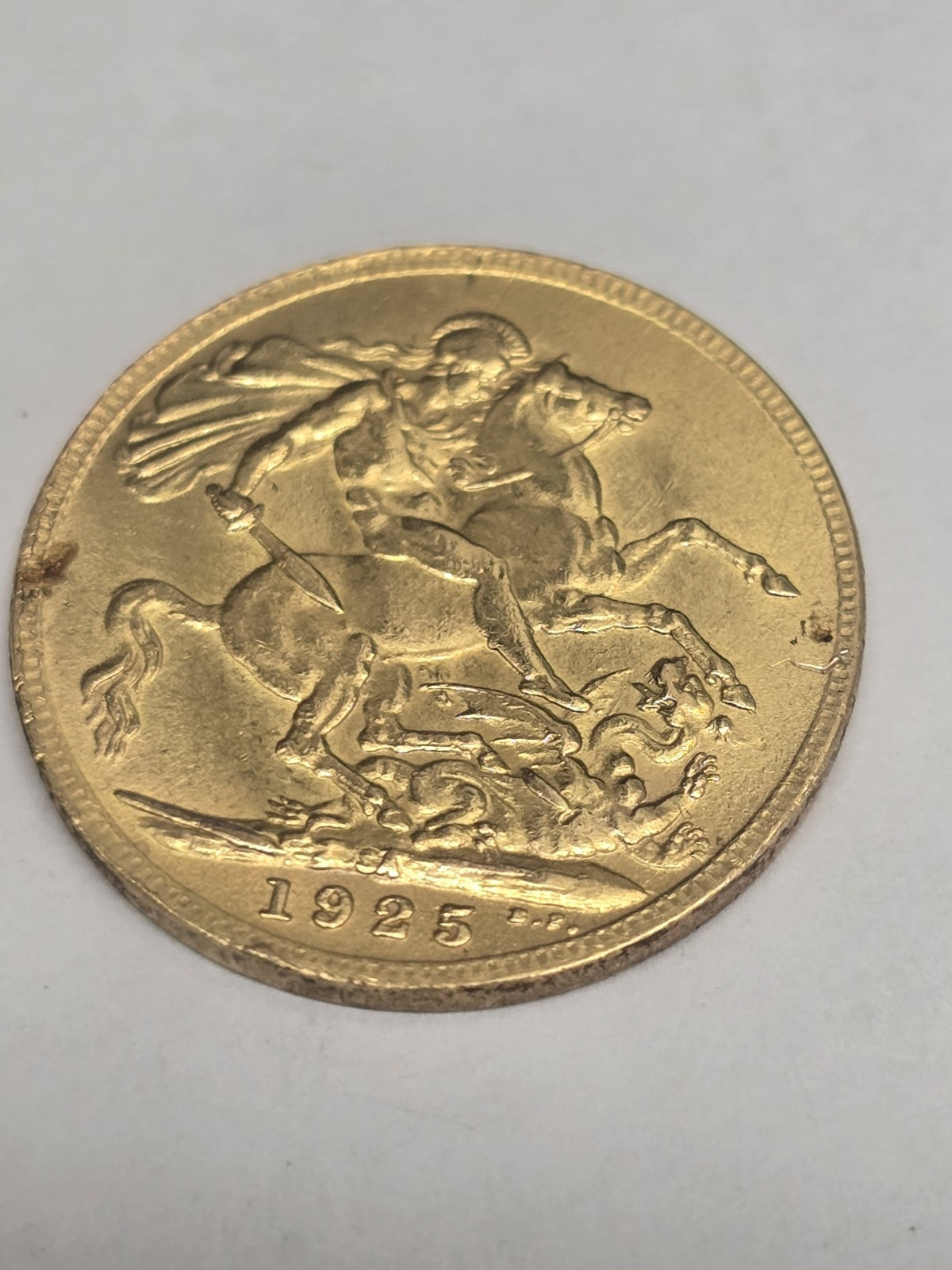 1925 Reeves and Sons full sovereign coin, 8g gold coin with detailed historical design and engraved inscriptions.