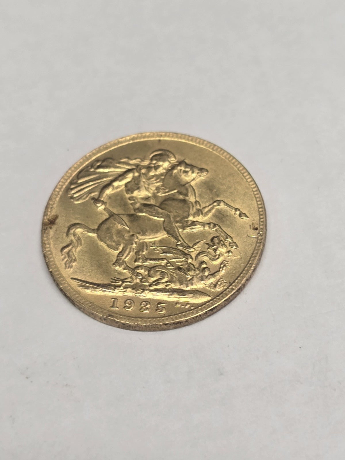 1925 Reeves and Sons full sovereign coin, 8g gold coin with detailed engravings and historical design.