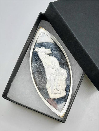 Silver ingot featuring The Queen's Beasts design by Reeves and Sons, showcasing a detailed embossed motif on a shiny silver surface.