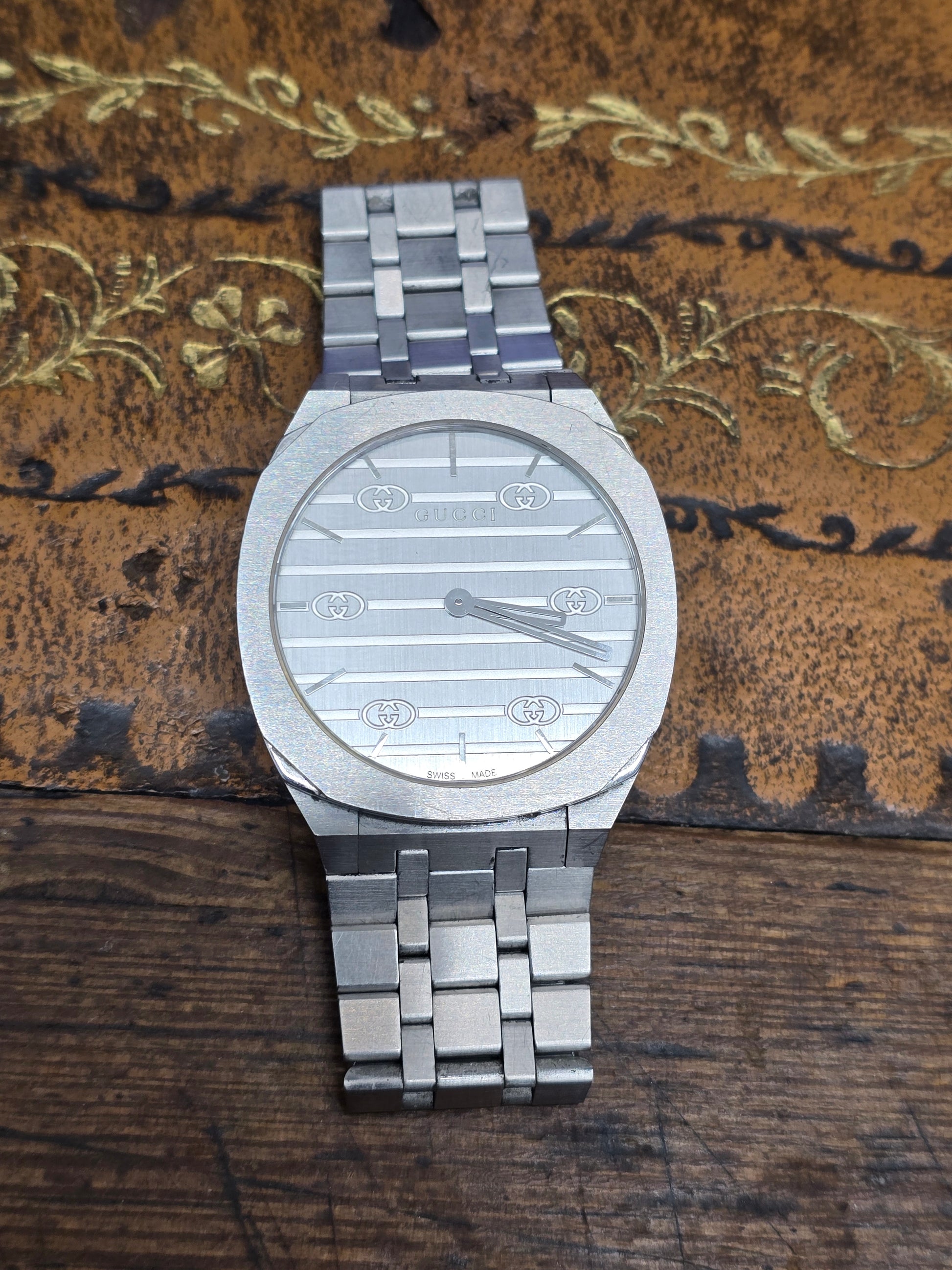 Reeves and Sons ladies Gucci watch box with accompanying paper, showcasing elegant packaging for a luxury watch.