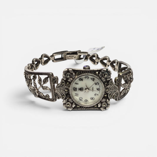Vintage floral bracelet watch with marcasite accents, ornate silver finish, Reeves and Sons quartz watch, detailed floral design.