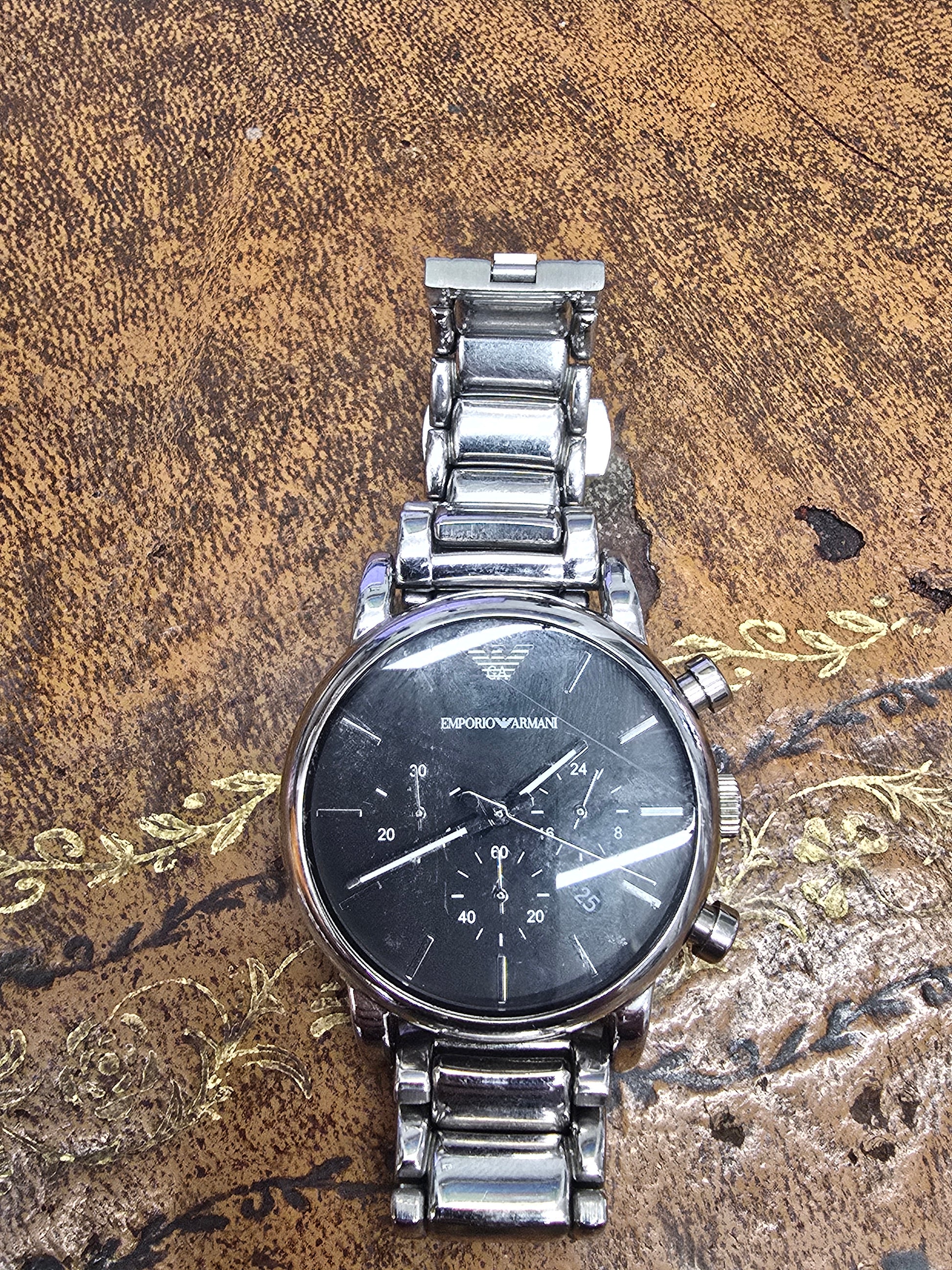Emporio Armani men's stainless steel chronograph watch with black dial and silver-tone band, displayed on a white background.
