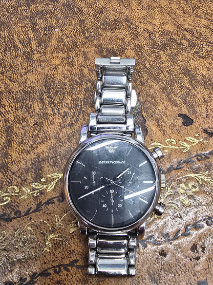 Emporio Armani men's stainless steel chronograph watch with black dial and silver-tone band, displayed on a white background.