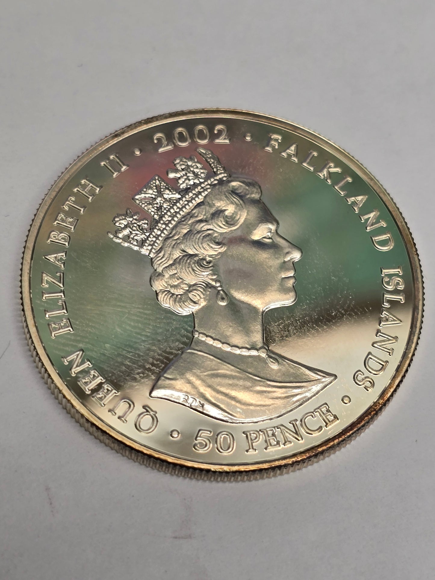 Silver 50 pence golden jubilee coin from 2002 by Reeves and Sons, showing detailed coin design on a plain background.