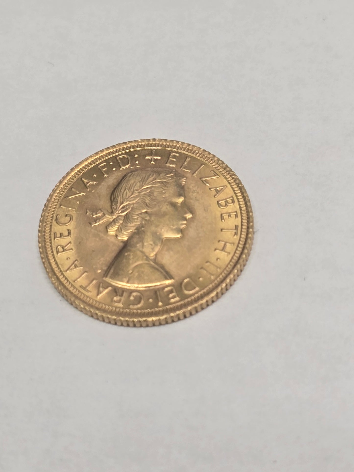 1966 Reeves and Sons gold sovereign coin in good condition, showing detailed portrait and classic design on the obverse.
