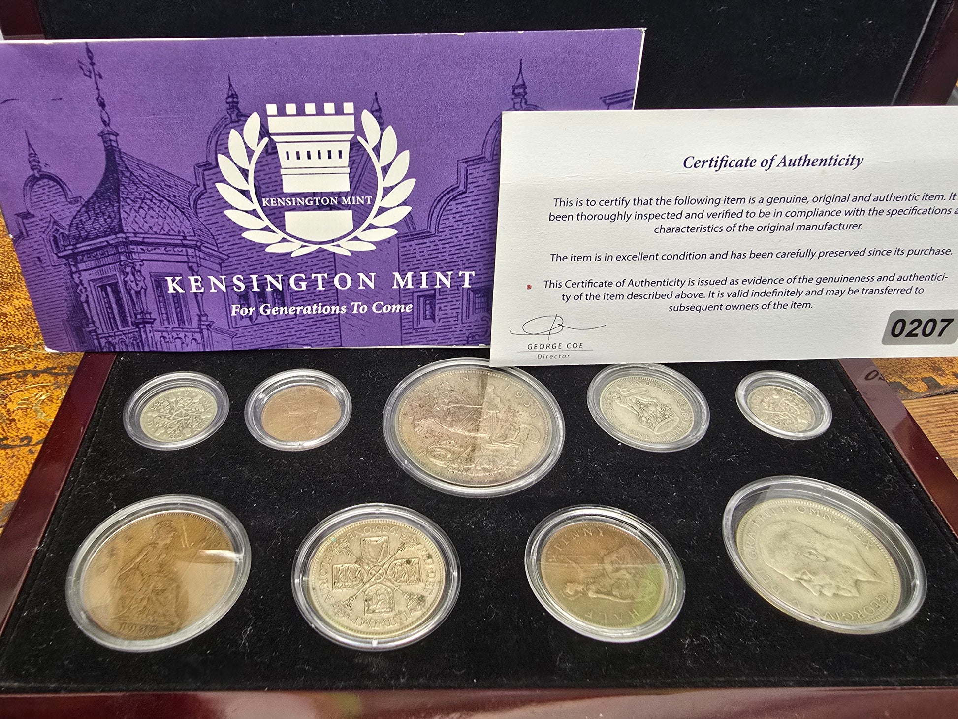 Silver coin from the Kensington Mint 1935 Silver Jubilee set by Reeves and Sons, shown with its box and certificate.