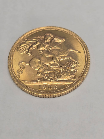 1966 Reeves and Sons gold sovereign coin in good condition, featuring detailed portrait and classic design on a reflective surface.