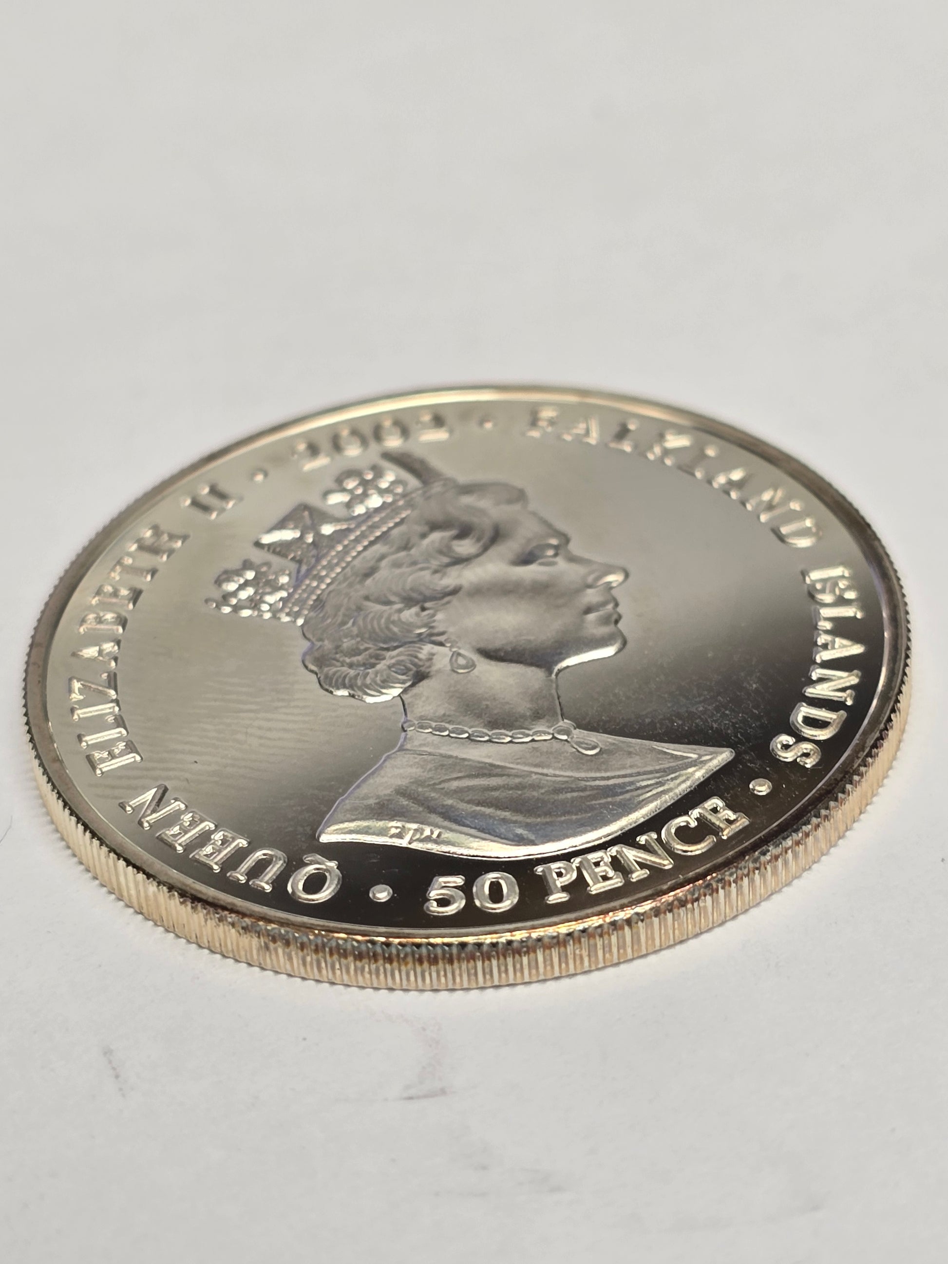 Silver 50 pence Golden Jubilee coin from 2002 by Reeves and Sons, featuring detailed Jubilee design and inscriptions.