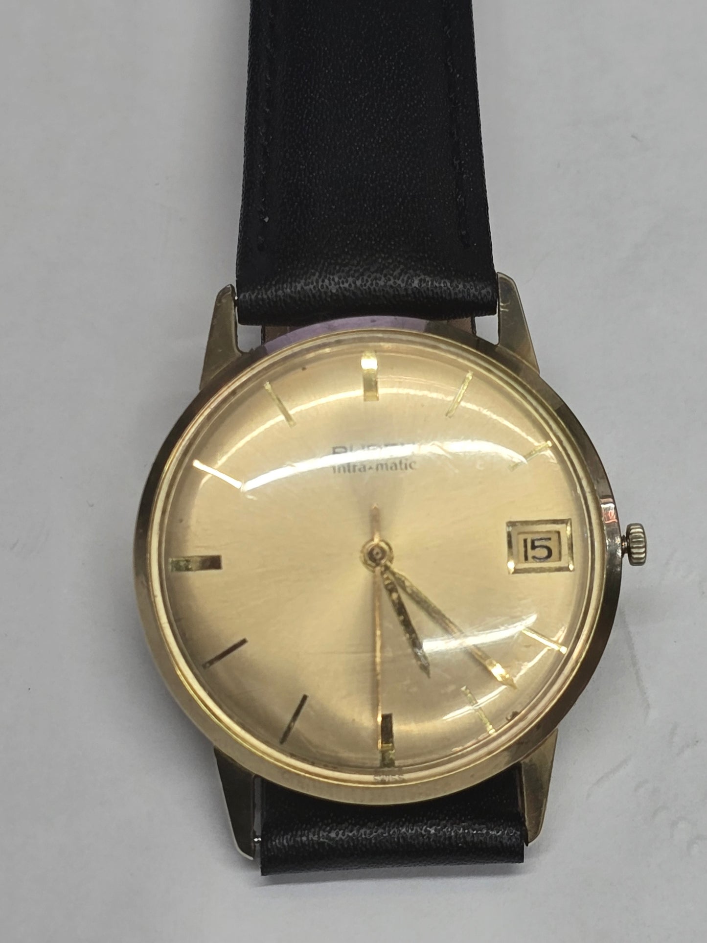 Vintage 9ct yellow gold Buren Intra-Matic automatic men's watch with Swiss craftsmanship, featuring a classic round dial and gold bracelet.