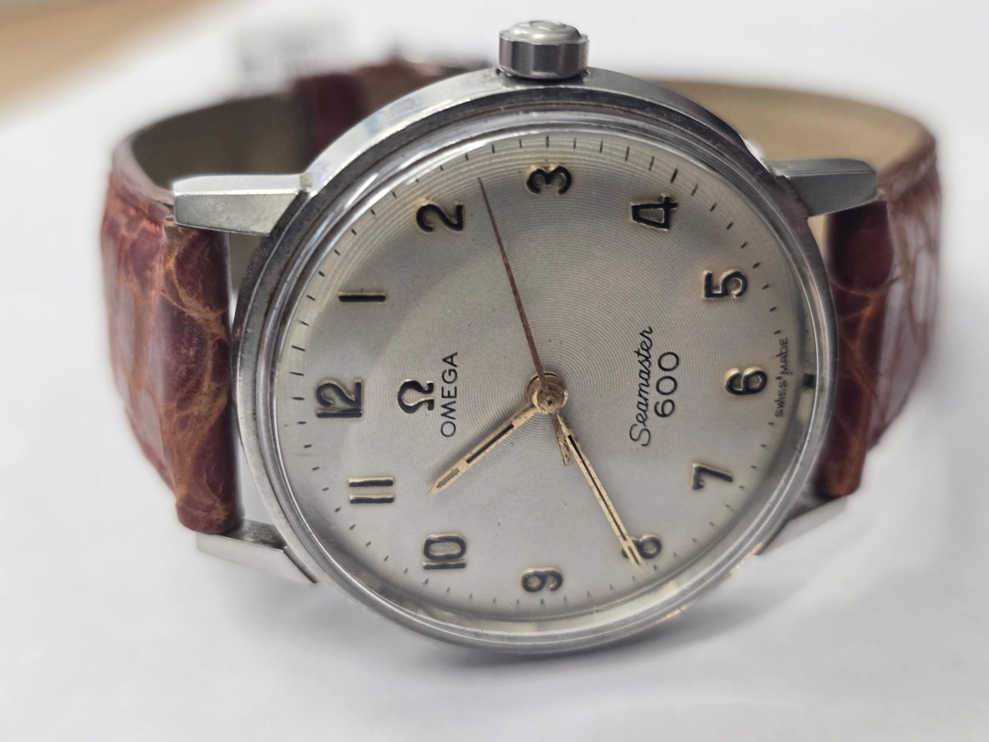 Vintage Omega Seamaster 600 Swiss watch with brown leather strap and classic dial, displayed on a plain background.