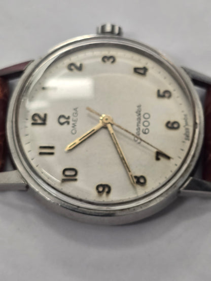 Vintage Omega Seamaster 600 Swiss-made watch with brown leather strap, featuring a classic round dial and stainless steel case.