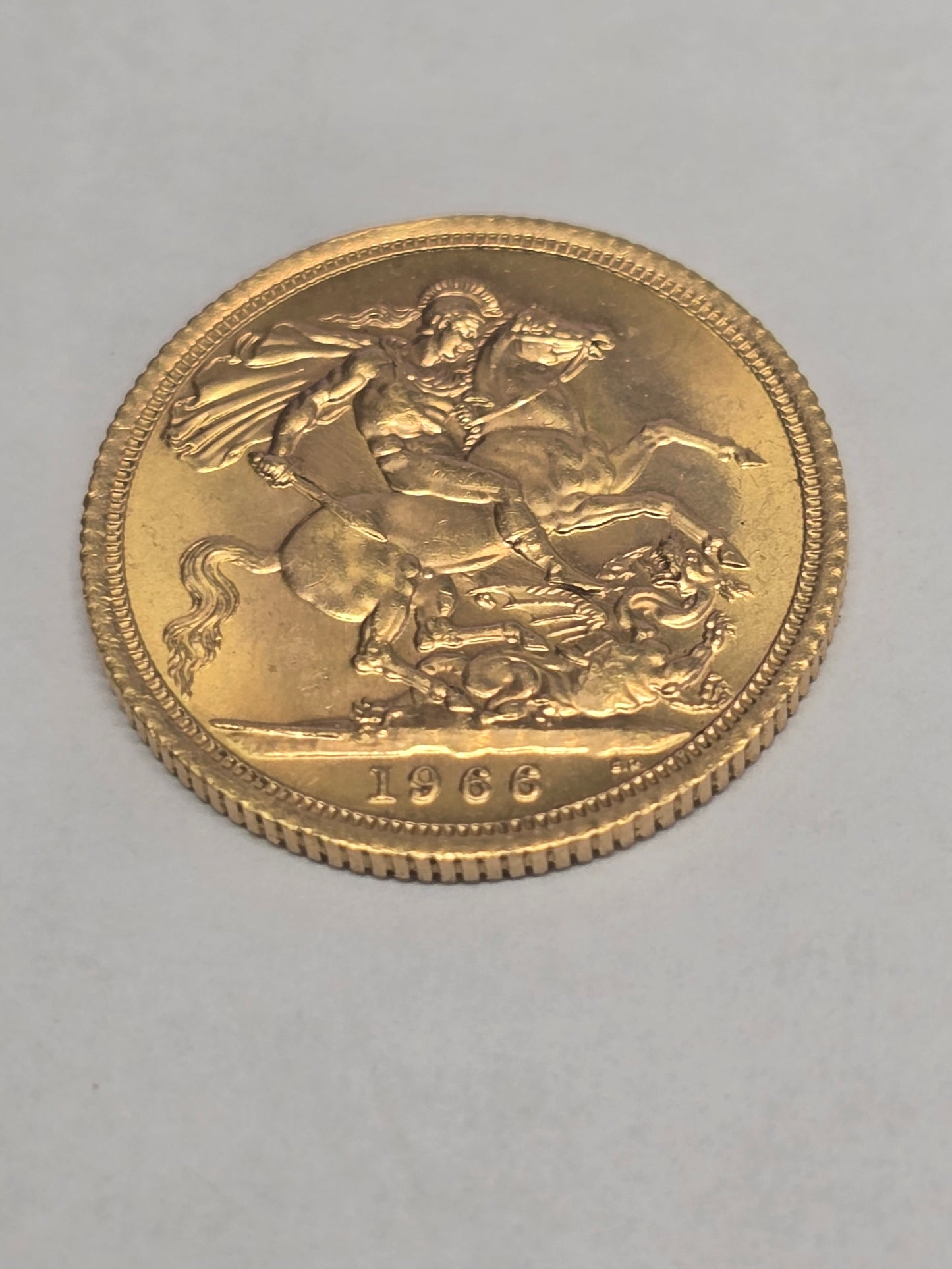 1966 Reeves and Sons gold sovereign coin in good condition, featuring detailed design and historic British currency imagery.