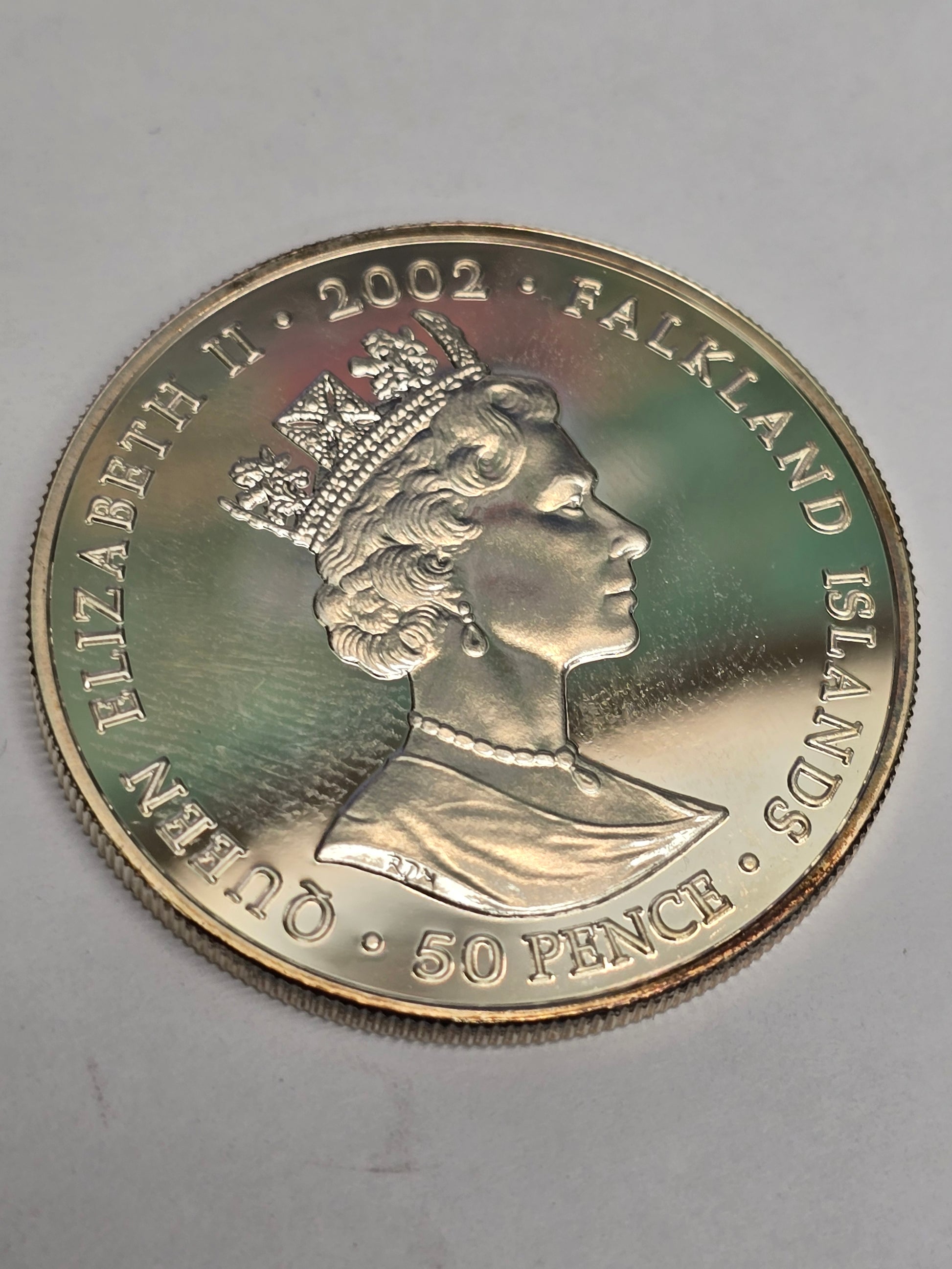 Silver 50 pence golden jubilee coin from 2002 by Reeves and Sons, showing the coin's detailed design and commemorative features.