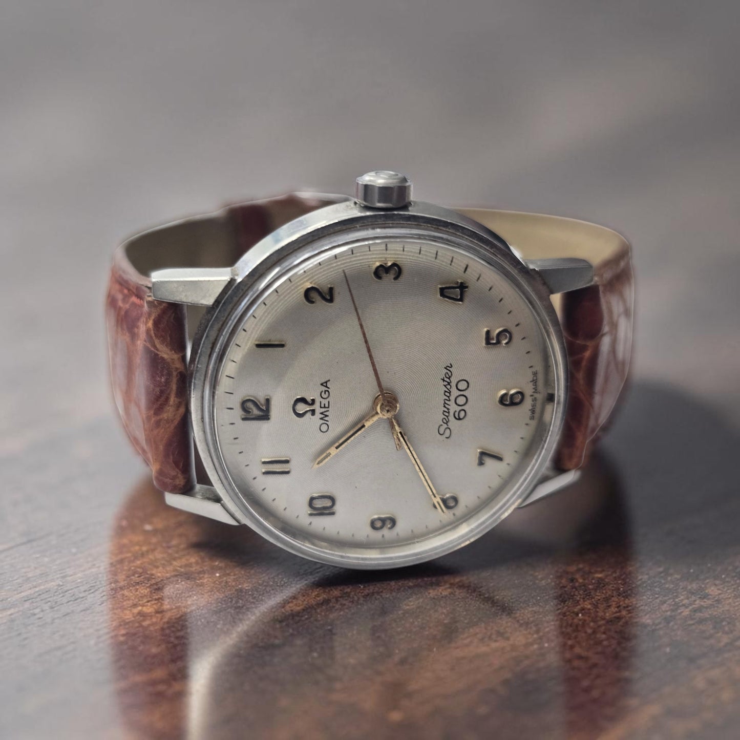 Vintage Omega Seamaster 600 Swiss-made watch with brown leather strap, featuring a classic design and detailed dial.