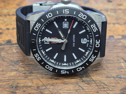 Reeves and Sons Navy SEAL style dive watch with black dial, rotating bezel, rubber strap, and water resistance up to 200 meters.