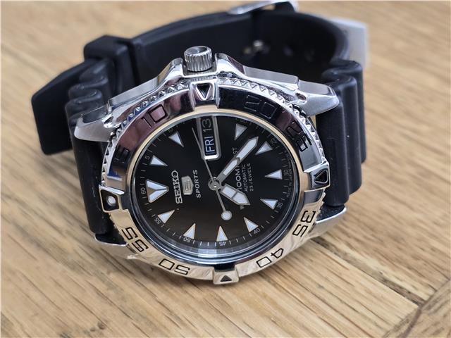 Seiko 5 Sports automatic watch with boxed papers, featuring a stainless steel case and black dial.