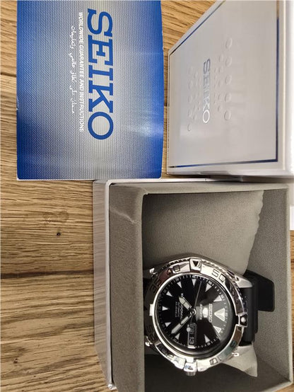 Seiko 5 Sports automatic watch with boxed papers, showing the watch face and stainless steel band.