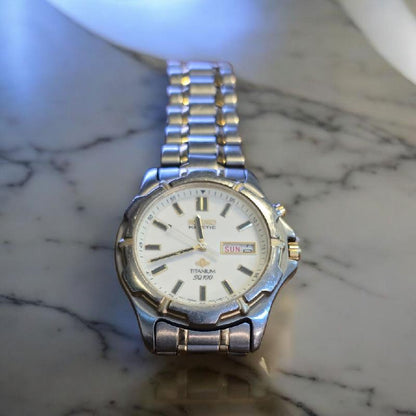 Seiko Kinetic Titanium SQ100 wristwatch with black dial and silver band, showcasing a sleek and modern design.
